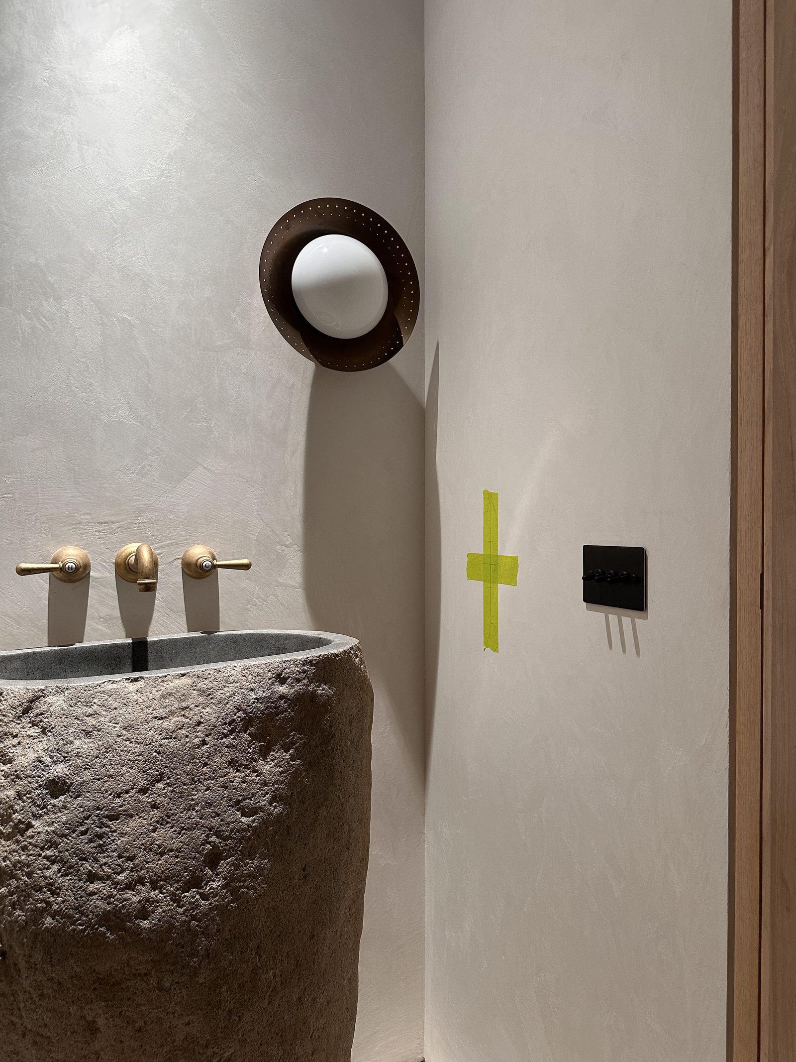 High end bathroom with a stone basin and brass tapware, marked and ready for the next fitting